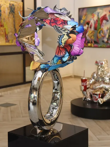 A freestanding sculpture from my Butterfly series, where a ring of polished steel becomes the foundation for a flurry of colorful wings. This piece explores themes of hope and continuous movement, designed to be viewed from all angles.