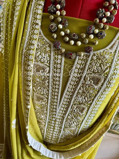 A close-up of the neckline, showing the detailed embroidery and the texture of the fabric.