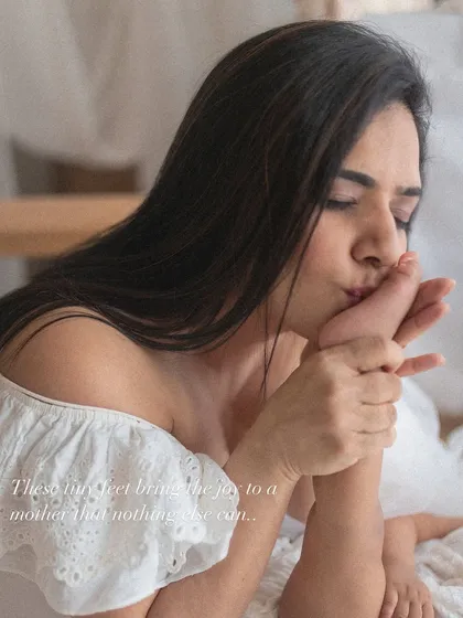 Kissing those tiny feet. It's a classic, tender gesture that every mother understands, a symbol of overwhelming love for her little one.