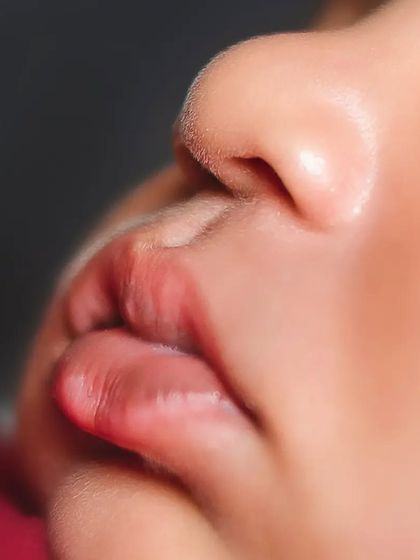 A close-up of a newborn's perfect little lips and nose. I use macro lenses to capture these features in beautiful detail.