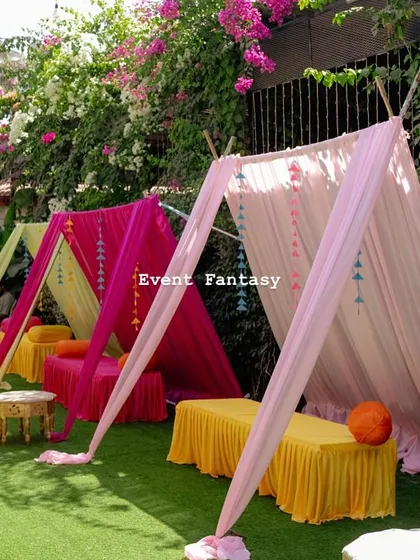 For a festive Mehandi, I set up these colorful cabana-style seating areas on the lawn. The bright pink, yellow, and blue drapes create a relaxed and celebratory vibe for the guests.