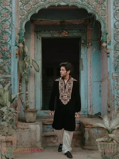 A stylish portrait of the groom against a rustic, textured doorway in Old Delhi. This shot highlights the unique character and charm of the location.