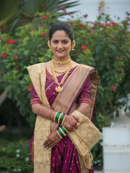 A radiant bride in a traditional purple and gold saree, her hands adorned with my intricate mehendi. This photo shows how the henna beautifully complements a classic bridal look.
