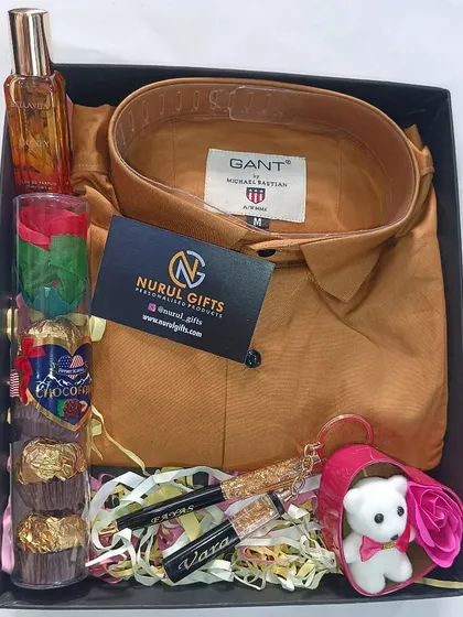 A Valentine's special gift box with a Gant shirt, perfume, personalized pen, chocolates, and a small teddy bear.