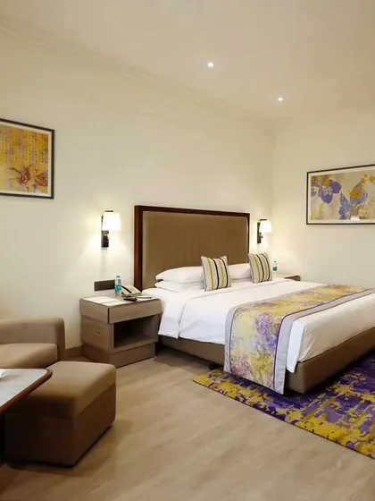 Another room configuration at Vivanta Bengaluru, showcasing a comfortable seating area and coordinated textiles. The design focuses on creating a premium stay experience through thoughtful details and elegant accents.