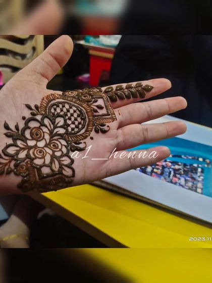 A small, intricate design on the palm, perfect for someone wanting just a touch of henna.