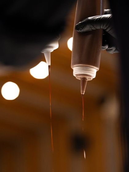 A beautifully composed shot of two squeeze bottles, ready to be used for plating and decorating with chocolate sauces.