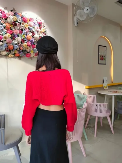 The back view of the red crochet bolero, showing its cropped style and fit. I can create custom apparel based on your specific designs.