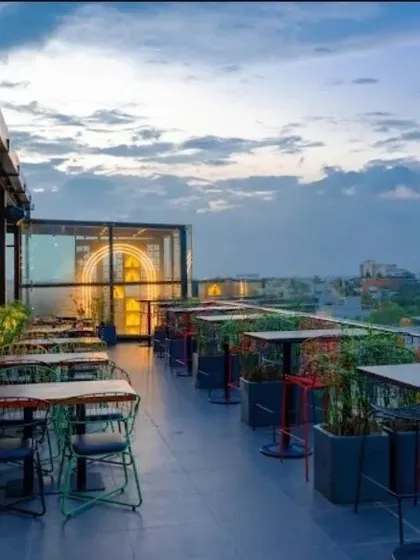 We designed the landscape for this rooftop restaurant and bar to create a vibrant atmosphere with panoramic city views at dusk. The space is defined by thoughtful planting in modern containers and flexible seating arrangements, blending an urban setting with natural elements.