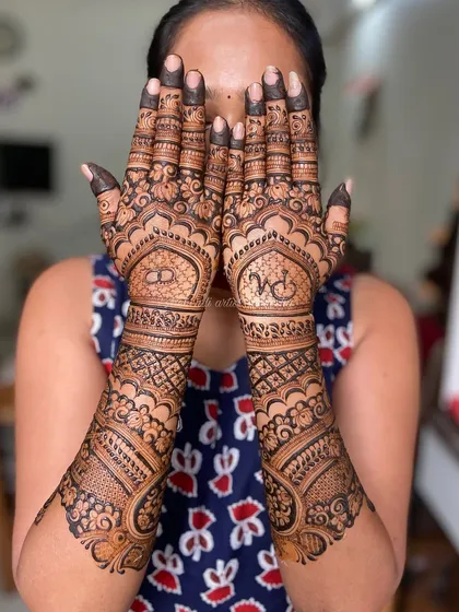 A lovely engagement design featuring the initials 'R' and 'M' within the intricate patterns on each hand.