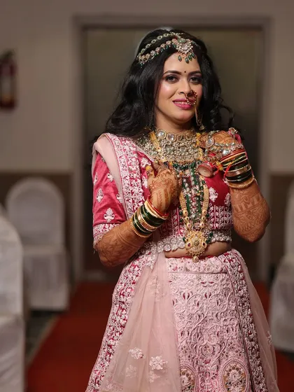 A confident pose from the bride-to-be, showcasing her stunning pink lehenga and perfectly coordinated makeup.