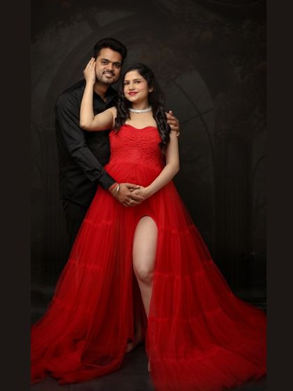From bump to bliss. This couple portrait in a stunning red gown against a dark backdrop is all about urban grace and maternity elegance.