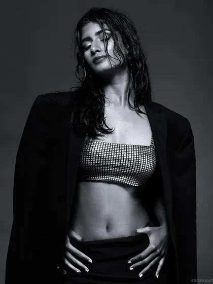A moody black and white portrait with a wet hair look. The shadows and highlights create a dramatic effect, focusing on the model's form and expression.