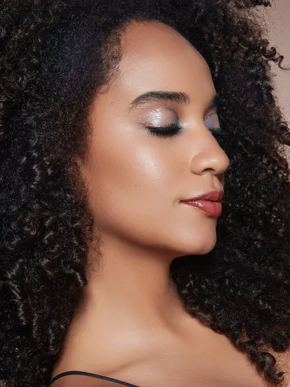 A soft, ethereal look with a wash of silver glitter on the eyelids. This demonstrates versatility, moving from bold looks to delicate and dreamy styles.