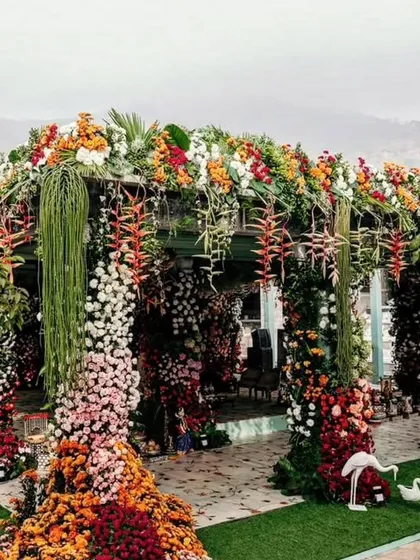 I believe in making a powerful first impression. This lavish floral entrance is designed to transport your guests into a world of beauty from the moment they arrive. The structure is completely covered in a rich tapestry of colorful, fresh flowers, showcasing my passion for abundant and artistic floral design.
