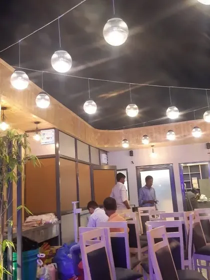 The open terrace restaurant at Nazeer in Noida. We designed the space with hanging globe lights and pine wood wall cladding to create a warm and inviting dining atmosphere.