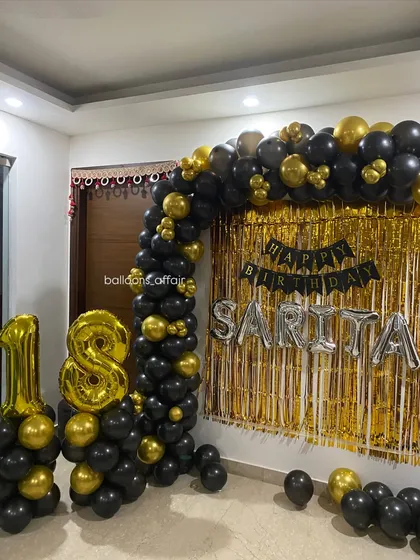 Another angle of the black and gold 18th birthday home decoration, showing the full balloon arch and backdrop.