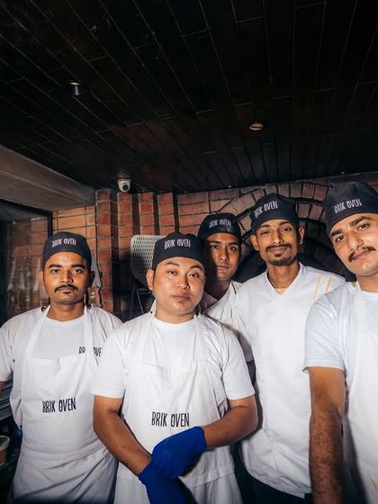 Wood-fired and stone-cold. Our crew poses for a photo, representing the cool confidence and hot skills that define the Brik Oven team.
