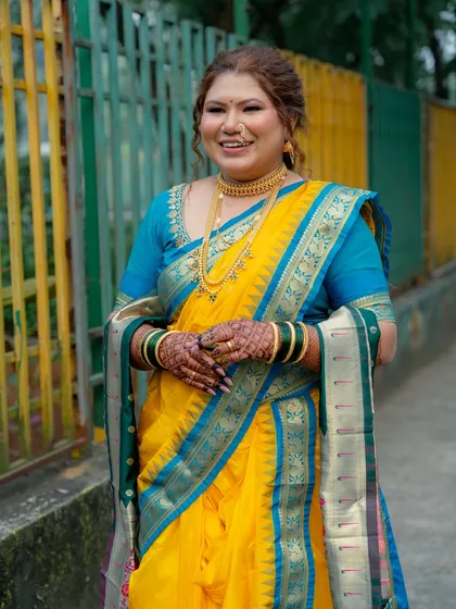 The bride's full look, showcasing the beautiful color combination of her saree and the elegance of her traditional jewelry.