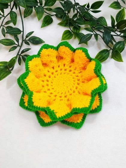 A bright yellow and green lotus coaster, reminiscent of a sunflower, perfect for adding a cheerful touch to any space.