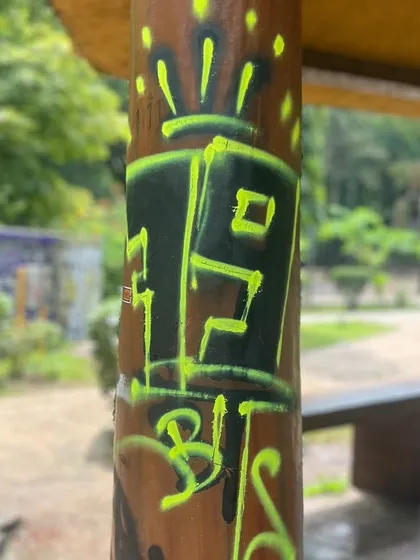A small tag on a park pillar. No surface is too small to leave a mark.