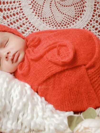 A detailed close-up of the baby's face, showing how the rich red color beautifully complements their skin tone.