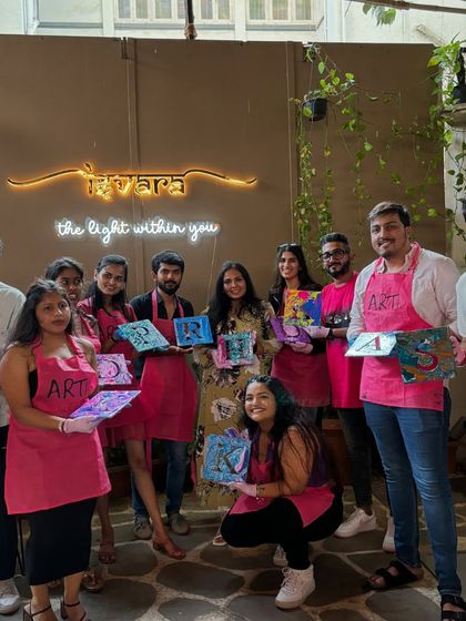 A group from a fluid art party, each holding a unique initial they created. The results of fluid art are always a fun surprise.