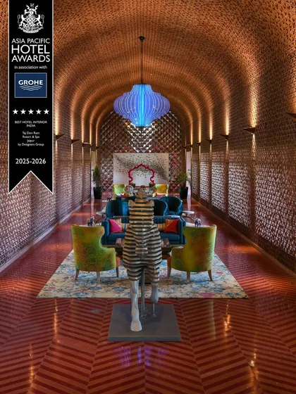 An award-winning corridor at the Taj Devi Ratn Resort, where traditional Rajasthani architectural forms are reimagined. The vaulted ceiling with intricate tile work and a vibrant blue statement chandelier create a dramatic and culturally rich passage for guests.