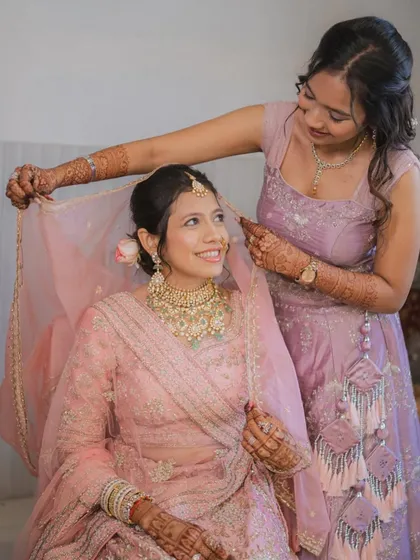 A sweet moment between the bride and her sister. It shows how the makeup looks natural and beautiful in candid moments.