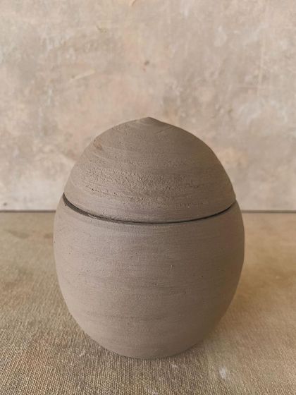 Another unglazed lidded jar, this one with a more rounded, organic shape. The beauty is in its simplicity and the visible texture of the clay.