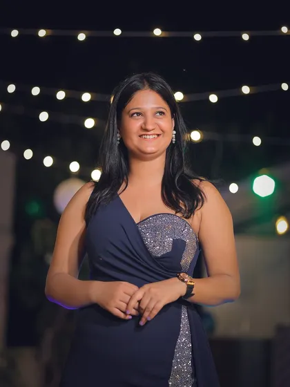 A candid portrait from an evening event, using the string lights to create a beautiful, warm bokeh background.