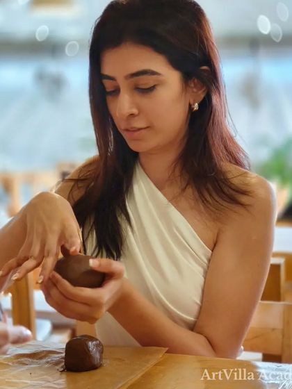 A participant at the Doolally workshop focuses on preparing her clay. We guide everyone through the basics, ensuring a great experience for beginners.
