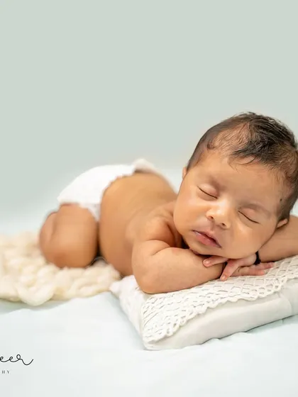 In this classic newborn pose, all the focus is on the baby's serene expression and tiny, perfect features. Using a simple, soft background, I create timeless portraits that highlight the pure beauty of your little one.