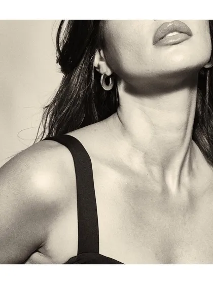 An artistic close-up in black and white. This type of abstract portrait focuses on details like the curve of the neck and lips, creating a sensual and evocative mood.