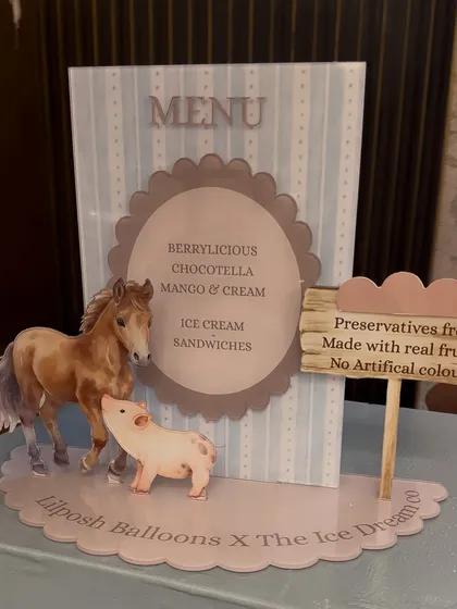 The adorable acrylic menu for the popsicle cart, featuring illustrated farm animals.