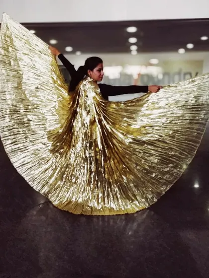 A dramatic pose with golden belly wings from our performance at the Landmark Family Fiesta. We incorporate props and stunning costumes to elevate our corporate stage shows.