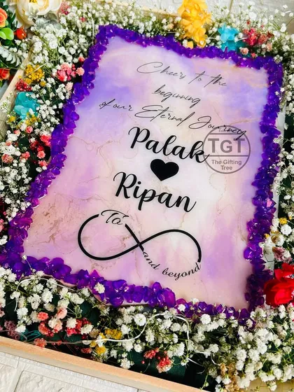 A 9x12 inch wedding invitation designed as a tabletop decor piece. This one features a purple stone border and comes in a beautiful gift box filled with flowers.