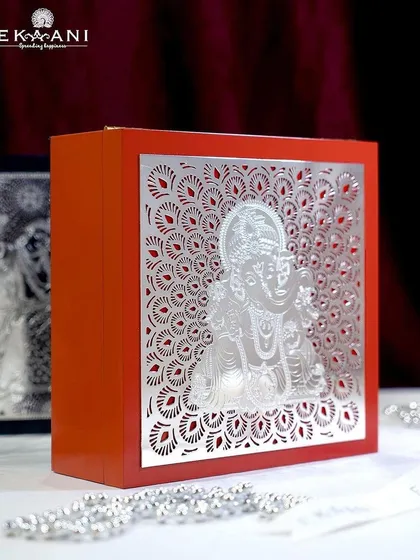 A bright orange gift box featuring a beautifully detailed silver-plated Ganesha. These boxes are designed to make your gift feel special before it is even opened.