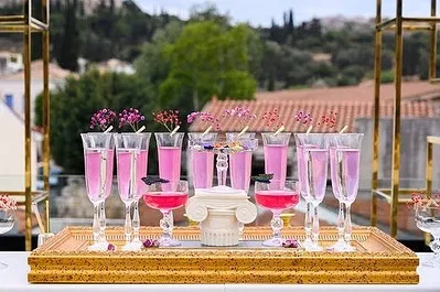 A closer look at the pink-themed cocktails for a destination wedding. The drinks are garnished with small flowers and custom butterfly tags, perfectly matching the romantic and whimsical decor.