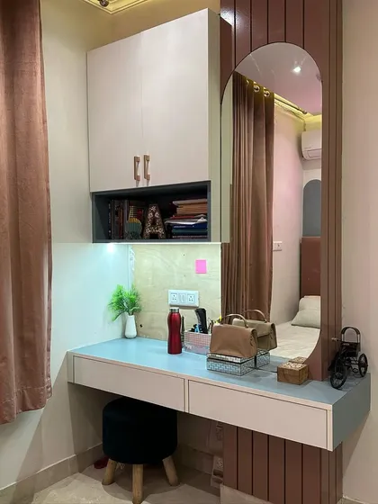 This custom-built unit serves as both a study desk and a dressing table. It includes a large arched mirror, overhead cabinets for storage, and integrated task lighting, making it a highly versatile and space-efficient solution.