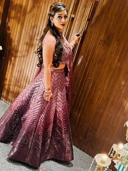 A side view of the wine-colored sequin lehenga, showing how it drapes beautifully. The matching dupatta has a ruffled border for an extra touch of style.