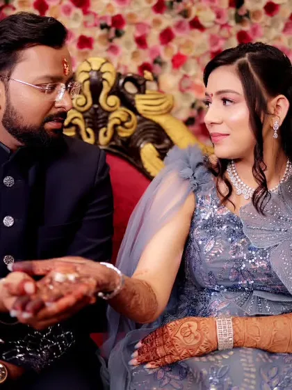 We capture the candid, unscripted moments during your engagement ceremony, like this sweet interaction between the couple against a beautiful floral backdrop.