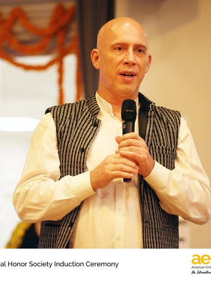 A faculty member speaks at the National Honor Society Induction Ceremony. This event celebrates students who have demonstrated outstanding dedication to scholarship, leadership, service, and character.