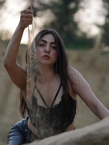 An unedited, raw shot from a desert-themed shoot, playing with sand for a natural and earthy feel.