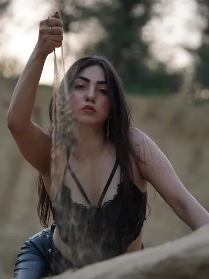 An unedited, raw shot from a desert-themed shoot, playing with sand for a natural and earthy feel.
