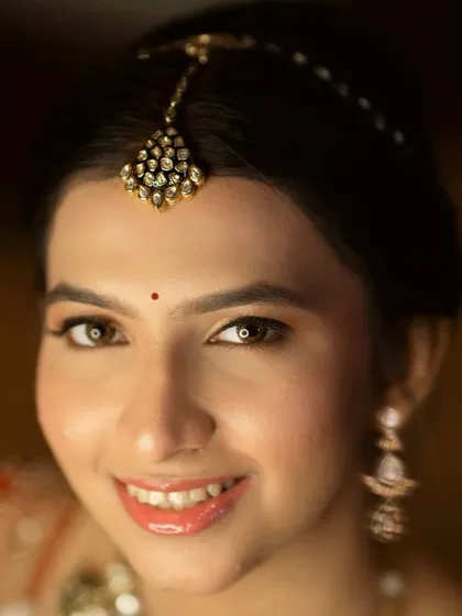 A close-up of a modern bride's makeup. The look is fresh and youthful, with glossy lips and soft, shimmery eyeshadow.