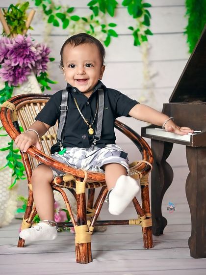 A toddler having fun at the miniature piano during his birthday shoot.