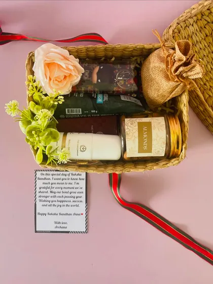 A top-down view of the Rakhi cane box hamper, showing the thoughtful message card and the curated gifts for a brother.