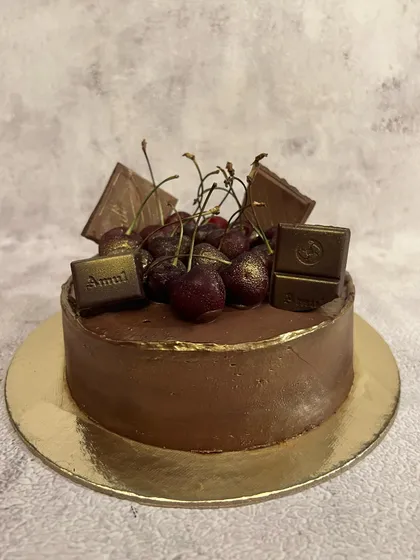 Our Belgian chocolate and cherry cake before its final decorations. The rich chocolate ganache is the perfect base for sweet, fresh cherries.