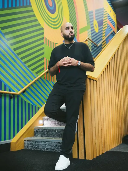 Posing against a vibrant, colorful wall. My work is about creating a multi-sensory experience, and that includes strong visuals.